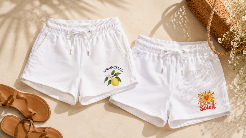 Deux shorts femme blancs à cordon, motifs Limoncello et Maman Soleil, avec sandales et panier en osier