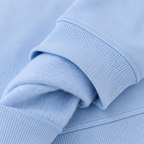 Zoom sur le poignet bord-côte et l'intérieur molleton gratté du sweat enfant bleu ciel